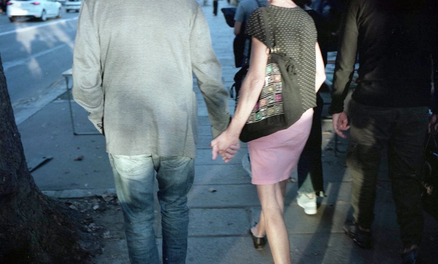 couple holding hands on the street